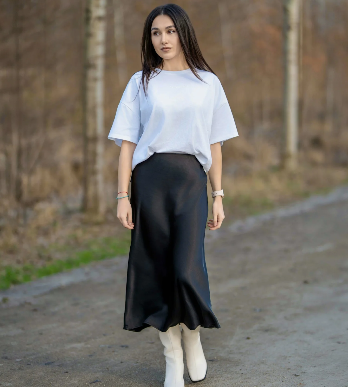 a woman in the forest wearing white top and long black skirt